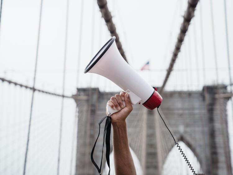 a man holding a loudspeaker aloft